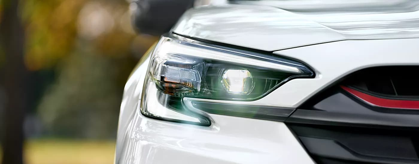 Close-up of the passenger side headlight on a white 2023 Subaru Legacy.