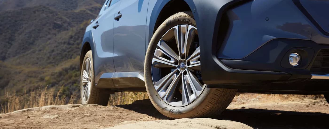 A close up of tires are shown on a blue 2023 Subaru Solterra.