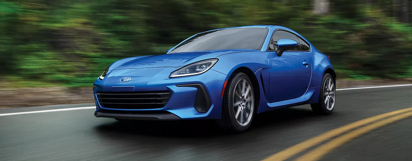 A blue 2023 Subaru BRZ Limited is shown rounding a corner after leaving a Subaru BRZ dealership.