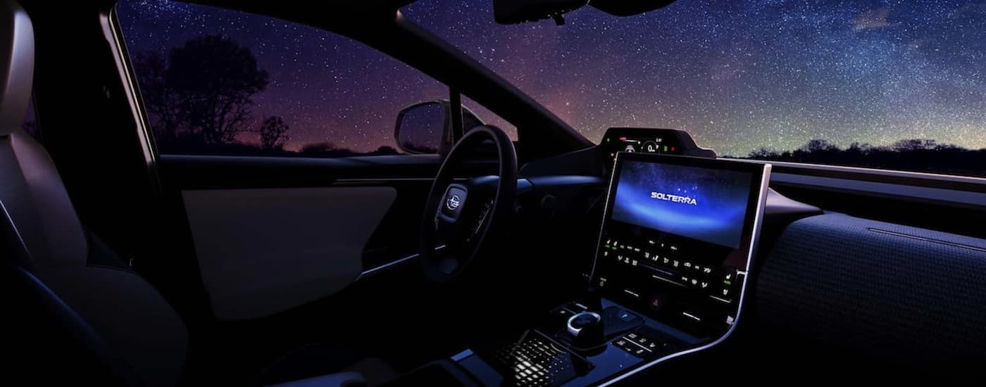 The interior of a 2023 Subaru Solterra is shown under a starry sky.