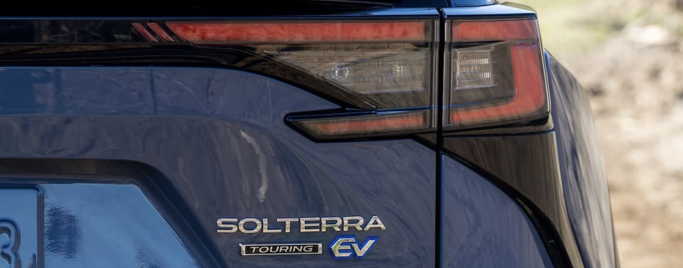 A close up shows the rear badging on a blue 2023 Subaru Solterra Touring.