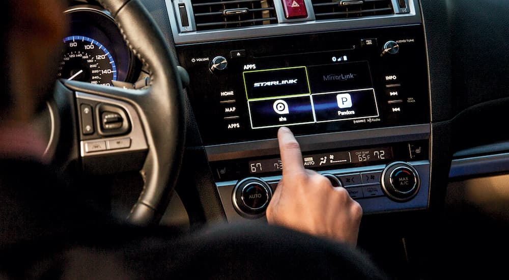 A close up of a person using the STARLINK feature in a 2016 Subaru Legacy.