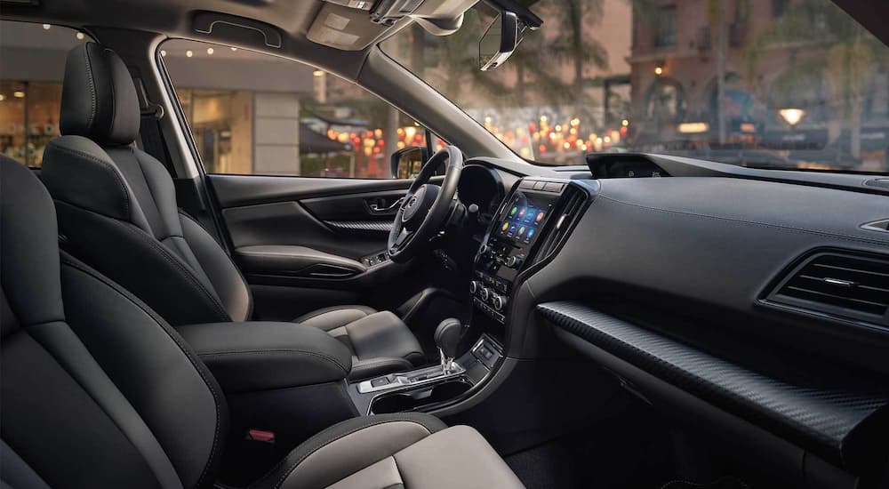 The black interior of a 2022 Subaru Ascent Onyx Edition shows the drivers seat and steering wheel.