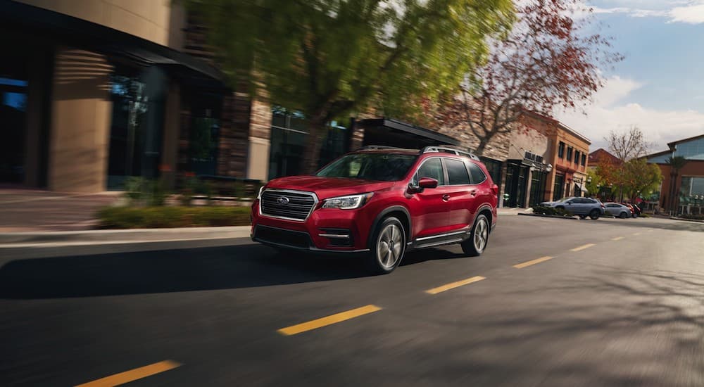 A red 2021 Subaru Ascent is shown leaving a certified pre-owned Subaru dealer in Charlotte.