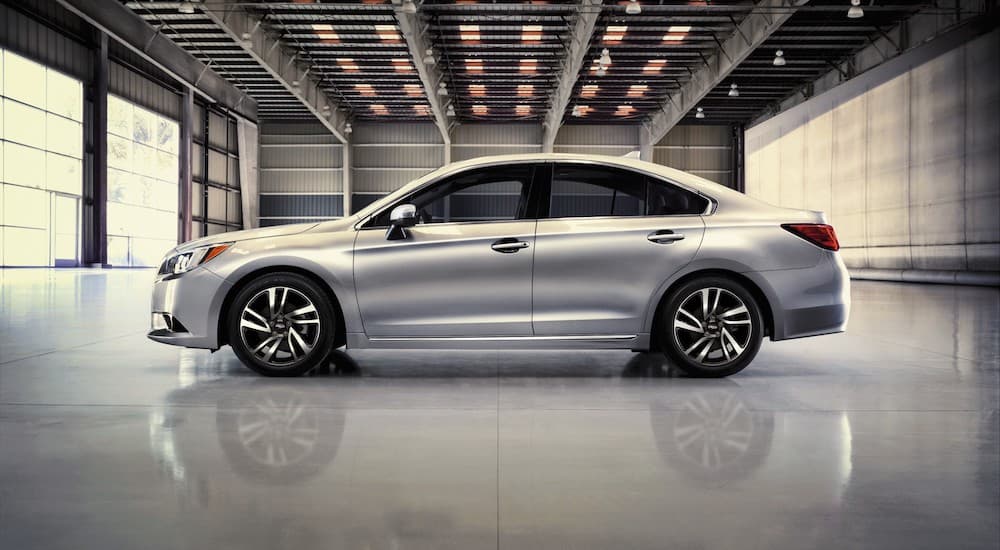 A silver 2016 Subaru Legacy Sport is shown from the side parked in a warehouse.