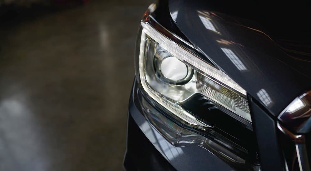 A close up shows the passenger side headlight on a dark grey 2018 Subaru Forester Black Edition.
