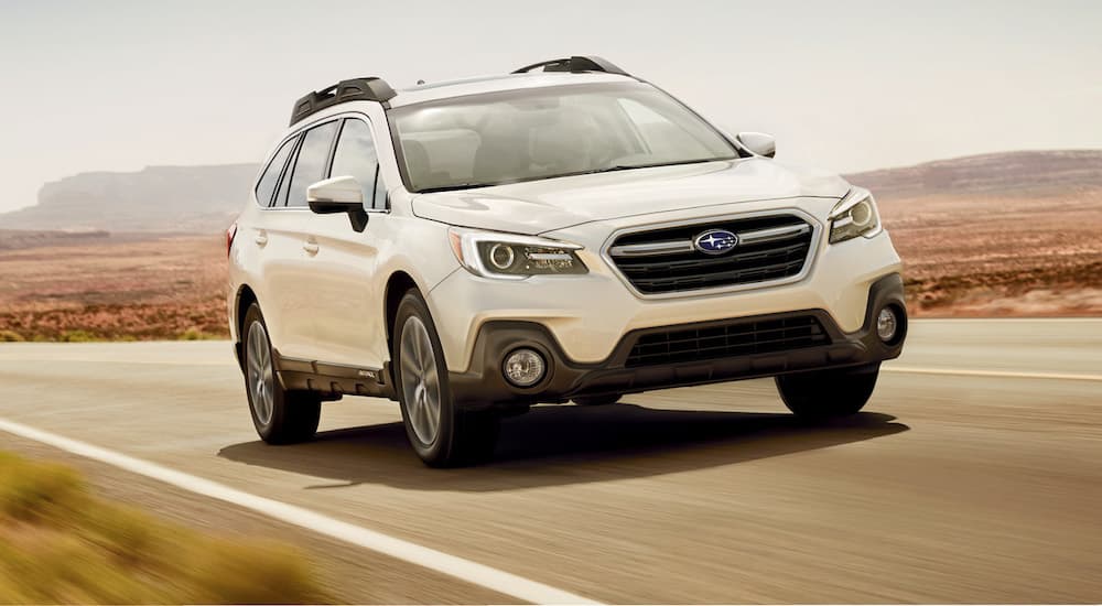 A white 2019 Subaru Outback is shown from the front at an angle.