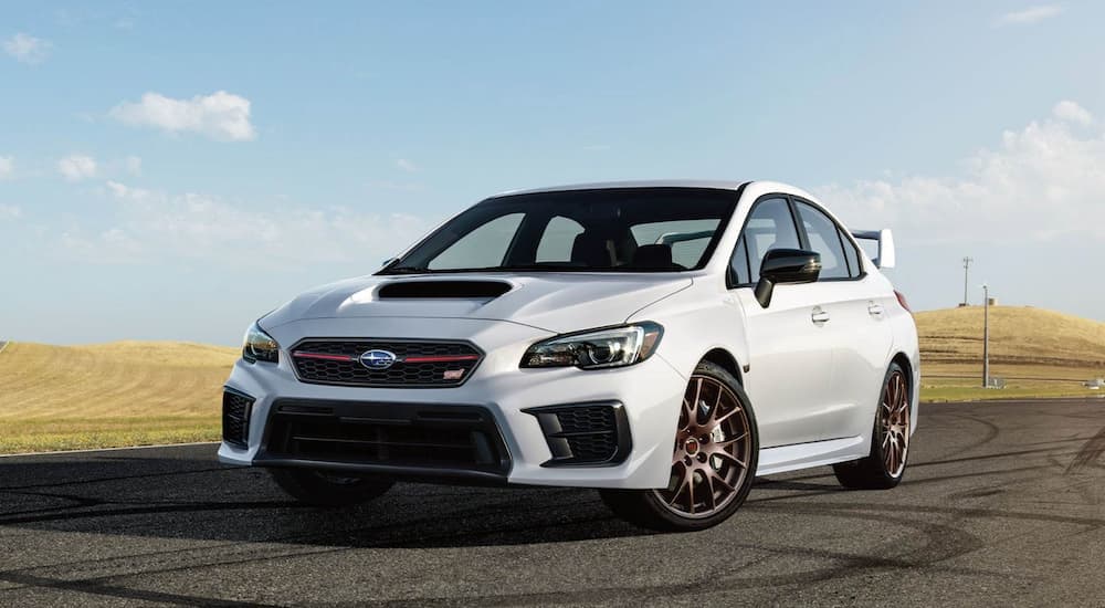 A white used Subaru for sale, a white 2020 Subaru WRX STI, is shown from the front.