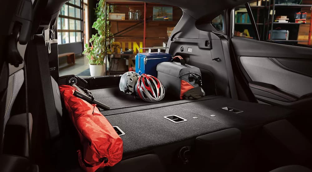 The rear cargo area of a 2023 Subaru Impreza packed with cycling and camping gear