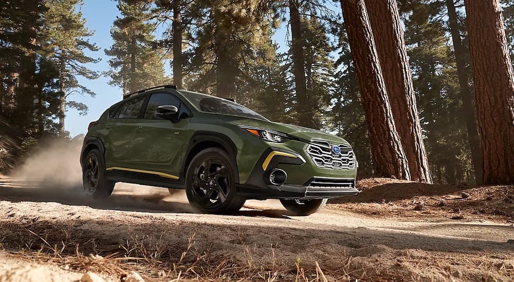 A green 2024 Subaru Crosstrek Wilderness is shown from the front at an angle after leaving a dealer that has a Subaru Crosstrek for sale.