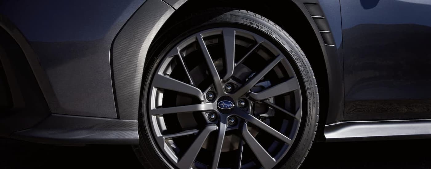 The black rim and tire is shown on a grey 2022 Subaru WRX GT.