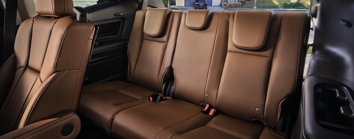 The brown leather interior of a 2023 Subaru Ascent with captain's chairs and third-row seating