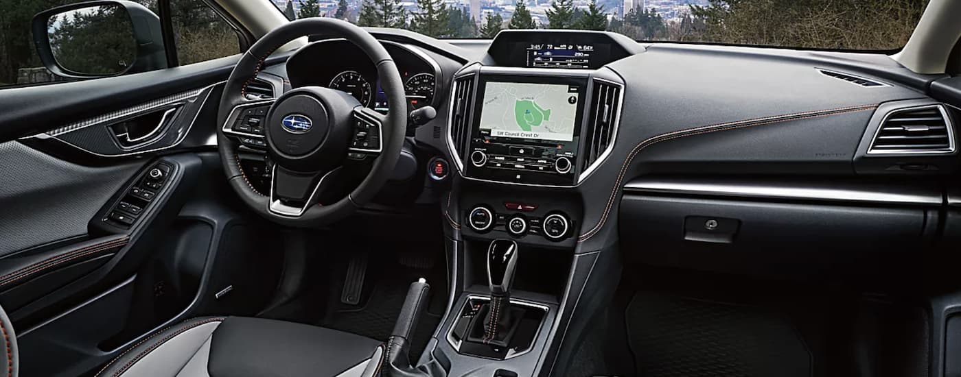 The black interior of a 2023 Subaru Crosstrek Limited shows the dashboard and infotainment screen.