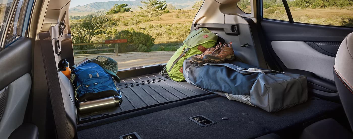 Parked near a trailhead, the cargo space of a 2023 Subaru Crosstrek has plenty of room for camping gear