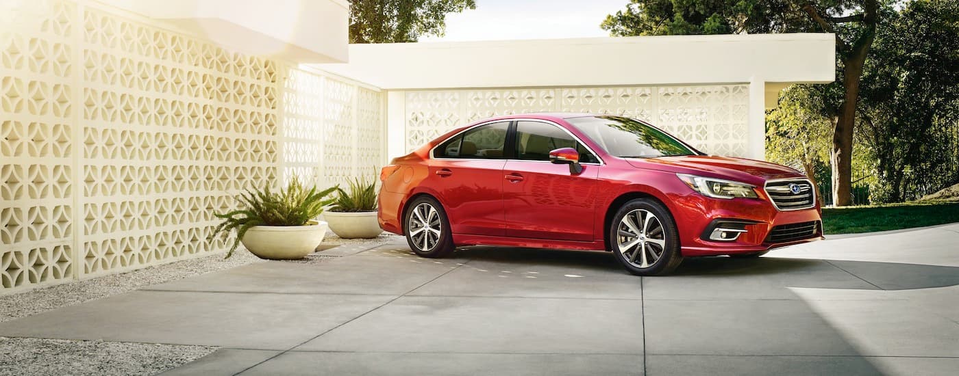 A red 2018 Subaru Legacy is parked in a driveway after leaving a Charlotte used car dealer.