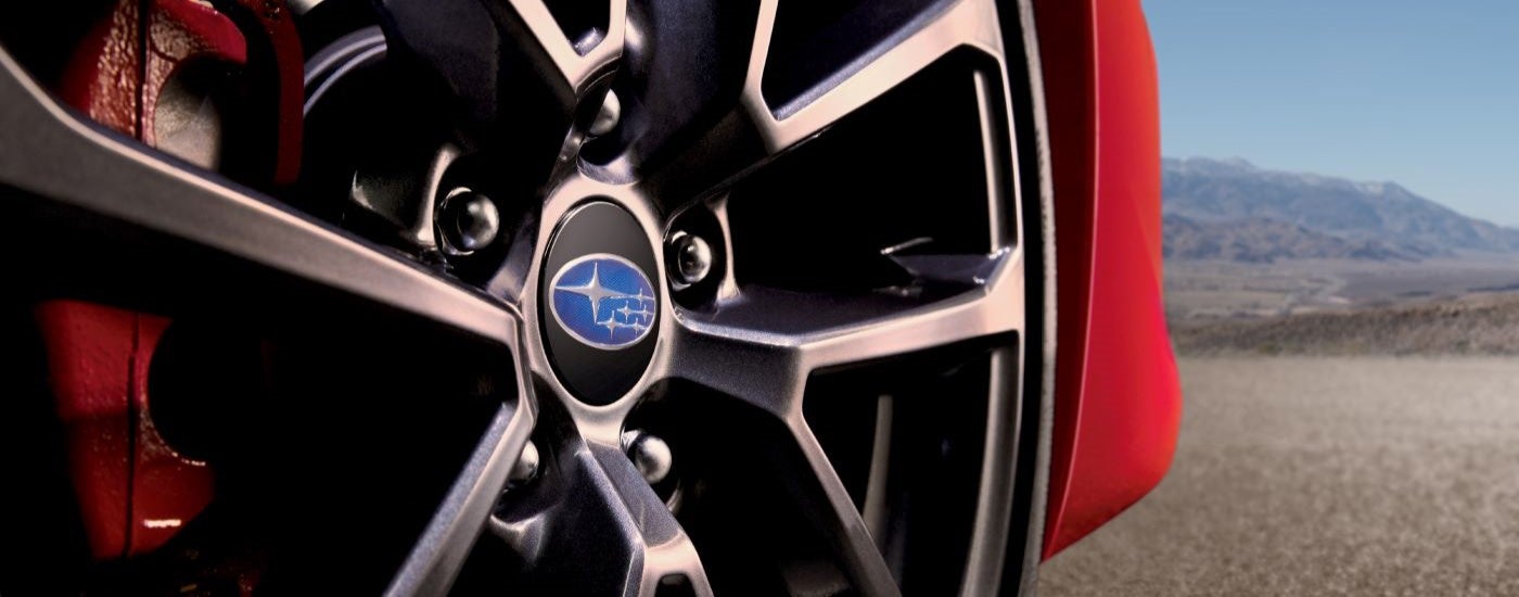 A close up shows the wheel and caliper on a red 2019 Subaru WRX Premium.