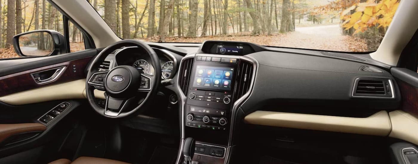 The brown and black interior of a 2022 Subaru Ascent shows the infotainment screen and steering wheel.