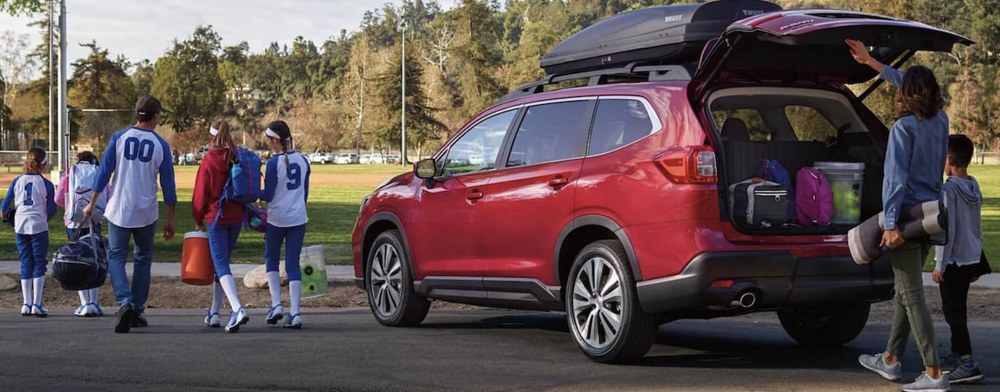 A little league team is getting out of a red 2021 Subaru Ascent, a popular option from a Subaru dealer near me.