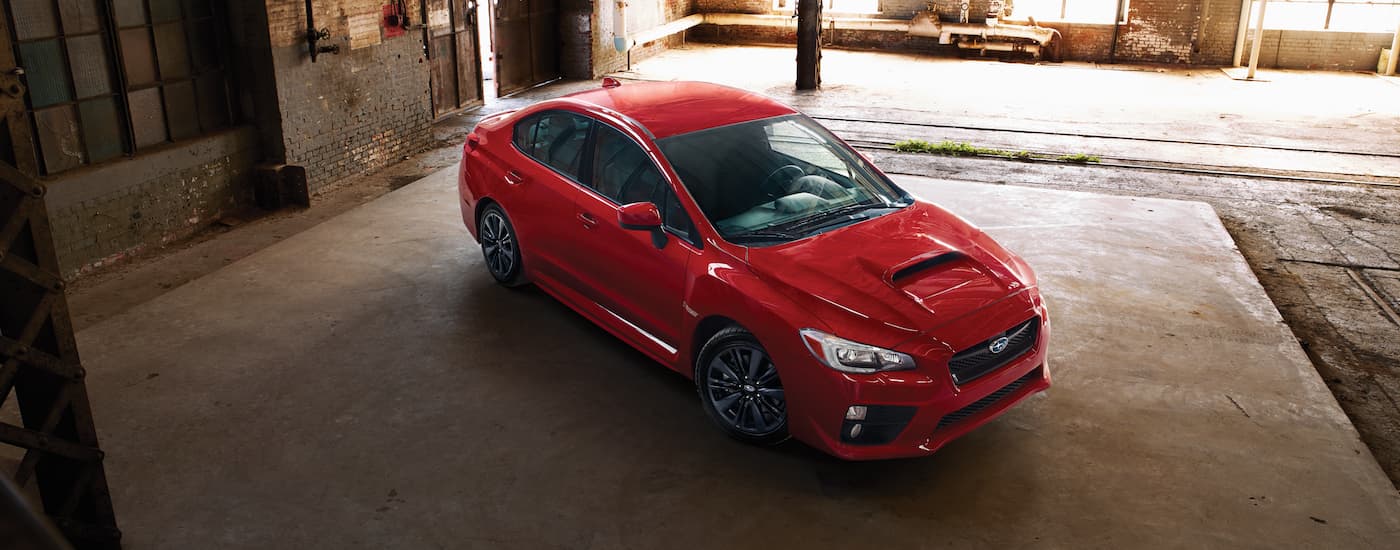 One of the most popular used Subarus for sale in Charlotte, a red 2017 Subaru WRX, is shown from a high angle in a warehouse.
